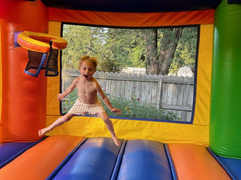 a child jumping on a bounce house
