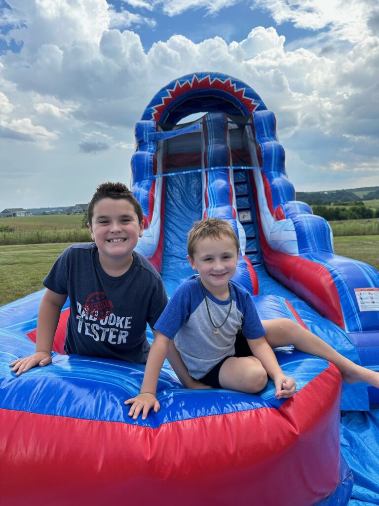 Kids smiling on water slide